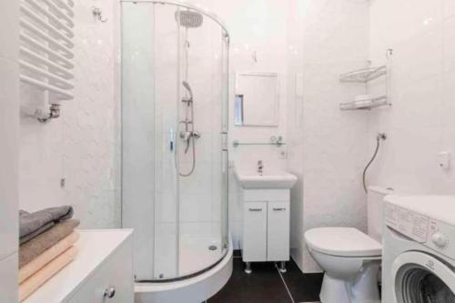 a bathroom with a shower and a toilet and a sink at Central Apartments & Wal25C in Gdańsk