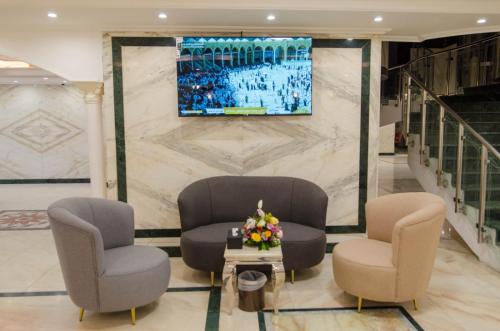 فندق درة بيسان في مكة المكرمة: لوبي بثلاث كراسي وتلفزيون على جدار
