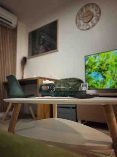 a living room with a desk with a computer on it at Suite Le Panoramique Near Disneyland in Montévrain