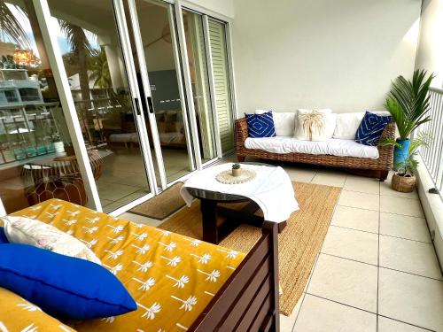 a living room with a couch and a table at Peppers Beach Club Penthouse in Palm Cove