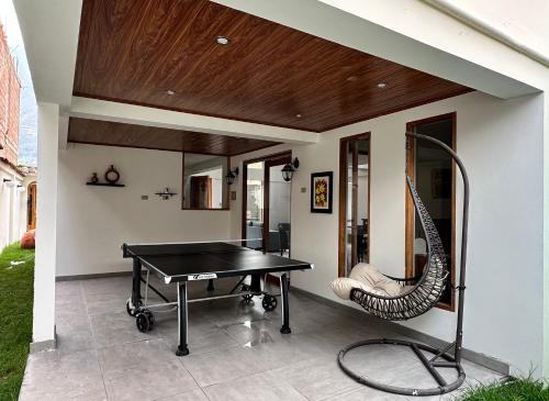 a ping pong table and a chair on a patio at Sacred Valley House in Calca