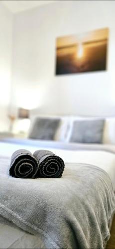 twee opgerolde handdoeken zittend op een bed bij 1 bedroom flat in Gravesend in Kent