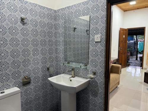 a bathroom with a sink and a mirror at Paris Garden Resort in Trincomalee