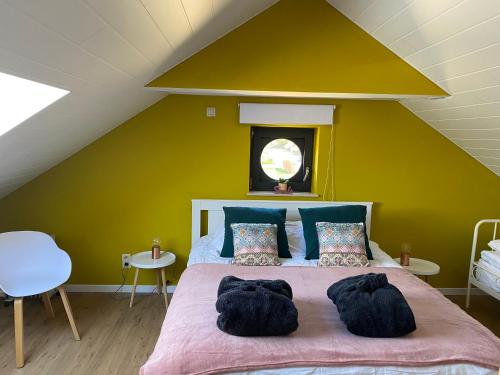 um quarto com uma cama grande e uma parede amarela em Le Gîte de l'espace bien être em Libin