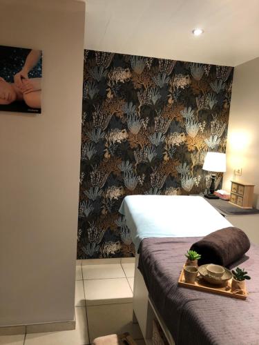 a bedroom with a bed and a wall at Le Gîte de l'espace bien être in Libin