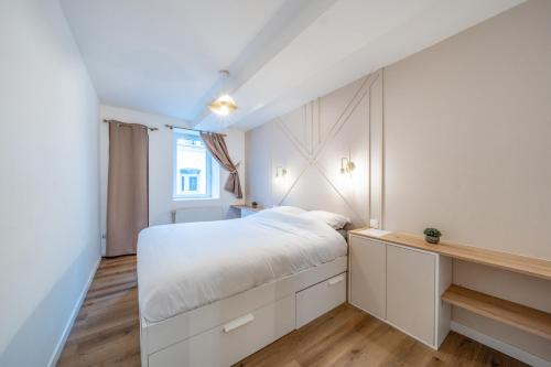 a bedroom with a white bed and a window at L'Evasion Amboise, Sauna Jacuzzi in Amboise