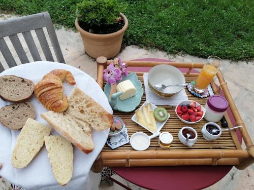 a breakfast tray with bread and toast on a table at L'Embellie un gîte tout confort et cocooning in Villefranche-sur-Saône
