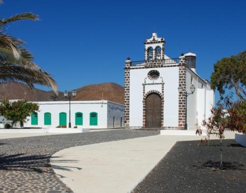 a white building with a clock tower on top of it at Casa Ines in Guatiza