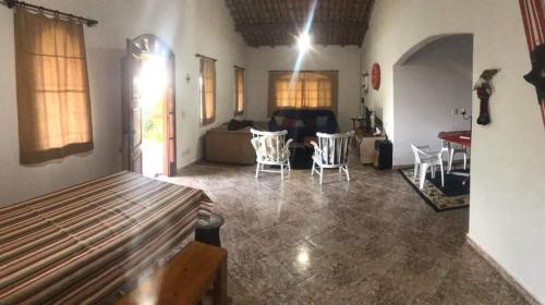 een woonkamer met een bank en een tafel en stoelen bij casa rosa in Cotia