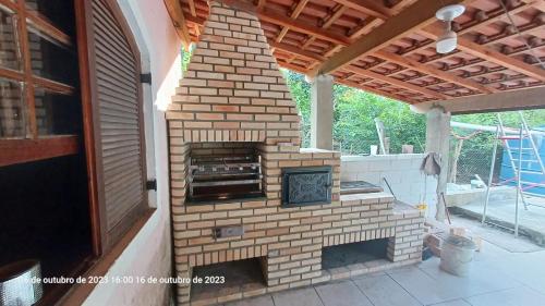 um forno de tijolo exterior num pátio em casa rosa em Cotia