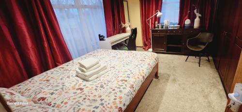 a bedroom with a bed with red curtains and a desk at Fox Lodge in Drogheda