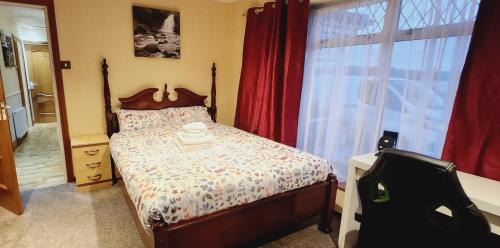 a bedroom with a bed and a large window at Fox Lodge in Drogheda