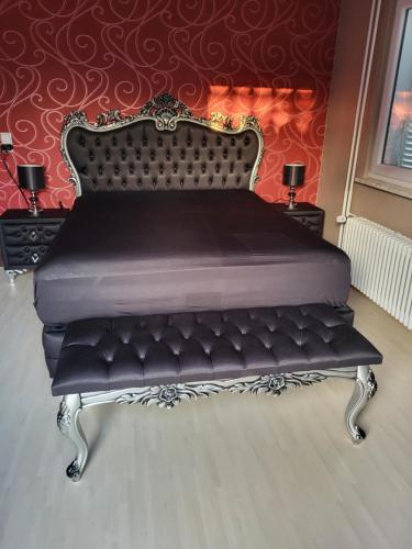 a bed with a black bench in a room at Gästehaus Mama in Rust
