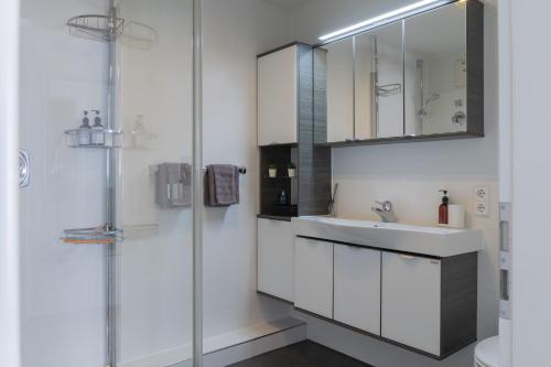 a white bathroom with a sink and a shower at CloudCabins No 1 - Traumblick im Herzen des Schwarzwaldes in Dornstetten