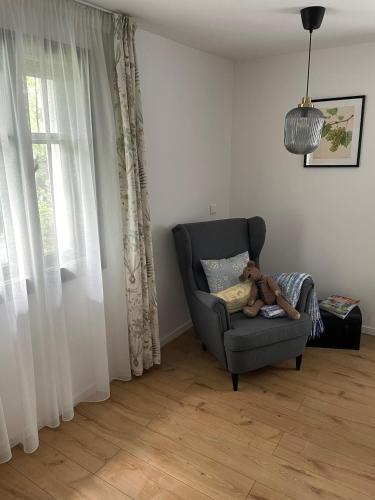 a teddy bear sitting on a chair in a living room at Itt és Most - Szent György-hegy in Raposka