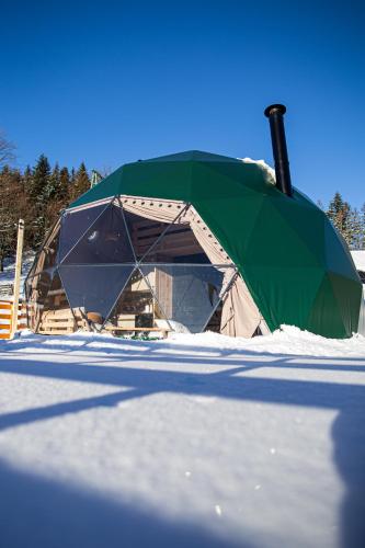 a green tent in the snow in a field at BUNNY GLAMP in Korbielów