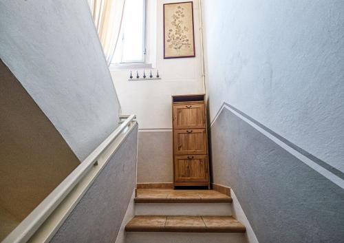 a stairway with a wooden cabinet and a window at Elle Home: comfort e comodo al centro in Bologna