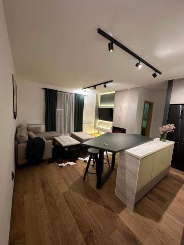 ein Wohnzimmer mit einem Tisch und einem Sofa in der Unterkunft Apartman 15 in Jahorina