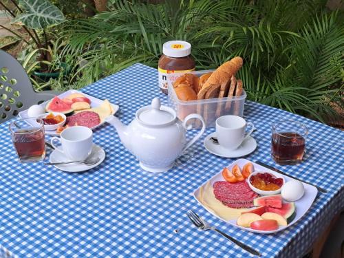 einen blauen und weißen Tisch mit Essen und einer Teekanne in der Unterkunft Mila Rest Garden in Mirissa