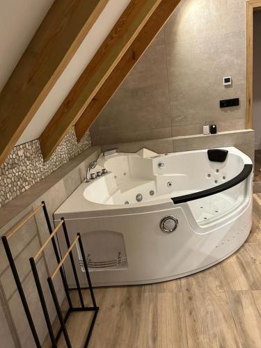 a large bath tub in a room with a ceiling at Dworek Willa Biała Góra in Biała Góra