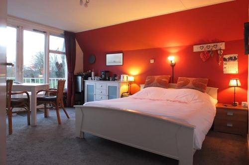 a bedroom with a large bed and a table and chairs at B&B Ferdivedaasje in Dokkum