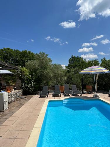 a swimming pool with chairs and an umbrella at Villa Garica in Garica