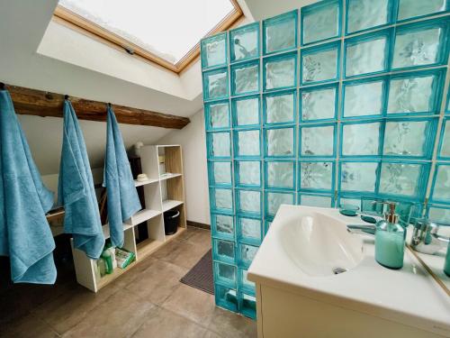 a bathroom with blue tiled walls and a sink at Duplex + parking gratuit facile in Sainte-Suzanne