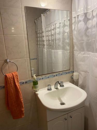 een badkamer met een wastafel en een spiegel bij LAS DACHAS 2 Villa Gesell in Villa Gesell