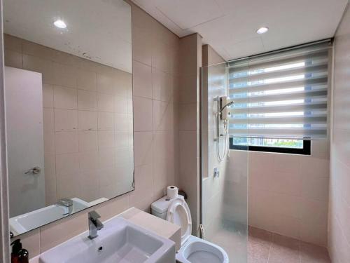 uma casa de banho com um lavatório, um WC e um espelho. em 2BR & 2BTH, with Free Parking Near Central Mall & Theme Park em Shah Alam