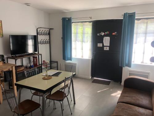 a living room with a table and chairs and a couch at Les Ateliers de la Villette Meublé de tourisme classé 2 étoiles T3 in La Ravoire