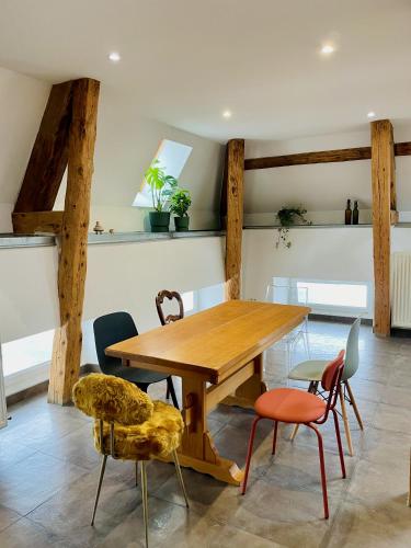 une salle à manger avec une table et des chaises en bois dans l'établissement Duplex + parking gratuit facile, à Sainte-Suzanne