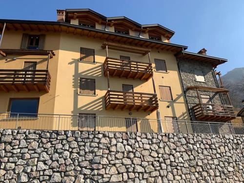 a building with a stone wall in front of it at Casa con vista in Costa di Serina