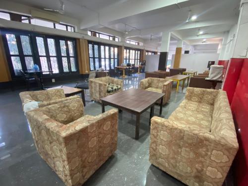 a waiting room with couches and tables and windows at Hotel Sova's Inn in Birātnagar