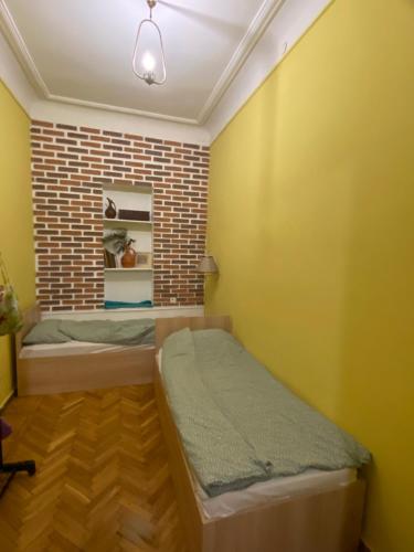 a bedroom with a bed and a brick wall at Hostel ERA in Tbilisi City