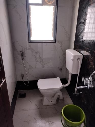 uma casa de banho com um WC branco e uma janela em Chinchwad Mohan nagar em Chinchwad