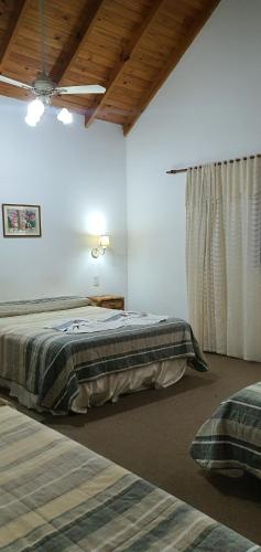 1 dormitorio con 2 camas y techo en Vagabonde hotel en Villa Gesell
