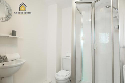 W łazience znajduje się toaleta i przeszklony prysznic. w obiekcie Spacious 2Bedroom 2Bathroom Flat in Warrington by Amazing Spaces Relocations Ltd. w mieście Warrington