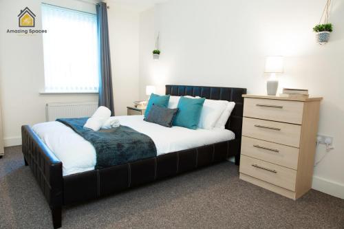 ウォリントンにあるSpacious 2Bedroom 2Bathroom Flat in Warrington by Amazing Spaces Relocations Ltd.のベッドルーム(大型ベッド1台、ドレッサー付)