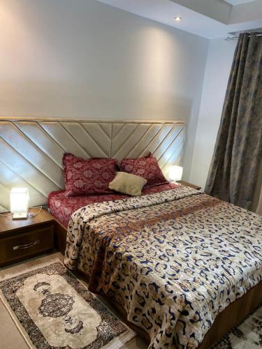 a bedroom with a large bed and two lamps at Palmeraies marsa in La Marsa