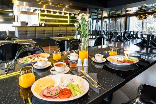 a table with plates of food and orange juice at Golden Lion House Bed&Breakfast in Rumia