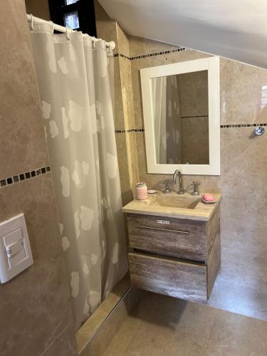 baño con lavabo y cortina de ducha en Complejo Médanos en San Bernardo