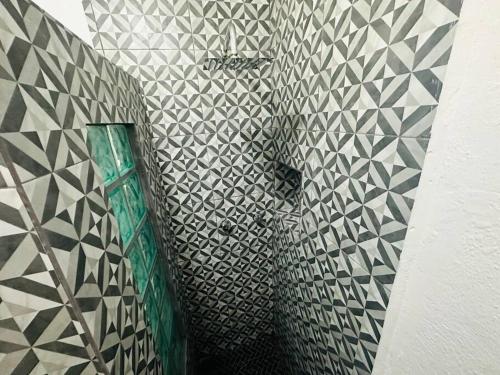 a bathroom with black and white tiles on a wall at Departamento 2 camas in Matamoros