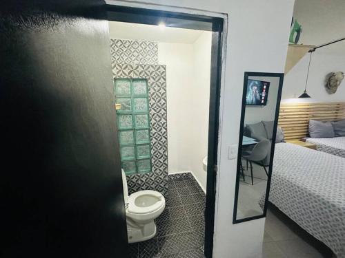 a bathroom with a toilet in a room with a bed at Departamento 2 camas in Matamoros