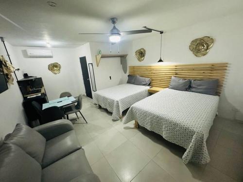 a bedroom with two beds and a desk and a couch at Departamento 2 camas in Matamoros