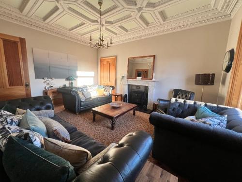 uma sala de estar com mobiliário de couro e um tecto em caixote em Morven Guest House Carnoustie em Carnoustie