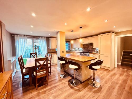 a kitchen and dining room with a table and chairs at Stunning 3BR House w/ Parking in Stevenage
