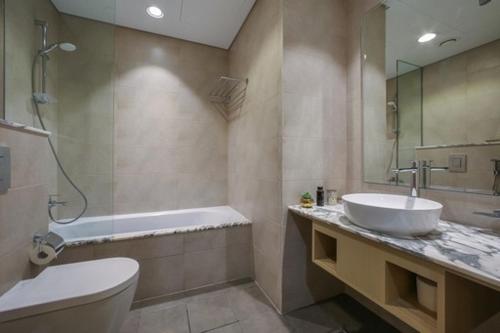uma casa de banho com um lavatório, uma banheira e um WC. em Luxurious one bedroom Apartment em Dubai