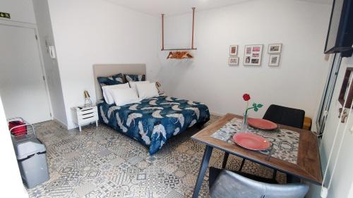 a small bedroom with a bed and a table with a table sidx sidx at Apartamento Burgo "Tanoeiros" in Funchal