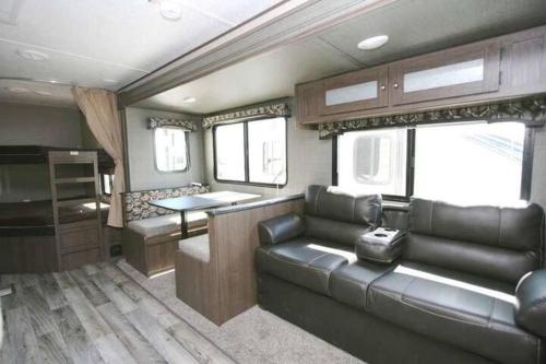 a living room with a couch and a kitchen in an rv at Golden Riverfront Campground in Golden