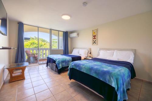 a hotel room with two beds and a balcony at Golden Dream Villas 306/A in Isabela